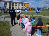 Policjantka z dziećmi podczas zajęć w miasteczku ruchu drogowego na szkolnym boisku