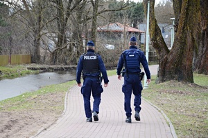 Dwóch policjantów idzie aleją