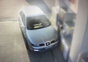 Samochód osobowy w srebrnym kolorze, który wjechał w dystrybutor na stacji paliw.